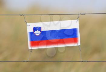 Border fence - Old plastic sign with a flag - Slovenia