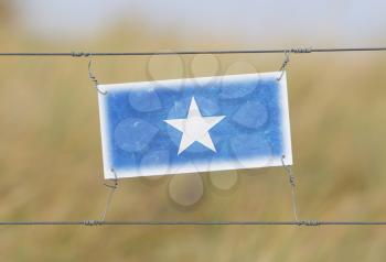 Border fence - Old plastic sign with a flag - Somalia