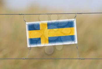 Border fence - Old plastic sign with a flag - Sweden