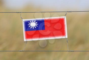Border fence - Old plastic sign with a flag - Taiwan