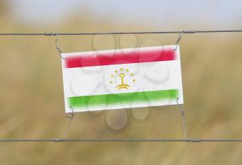 Border fence - Old plastic sign with a flag - Tajikistan