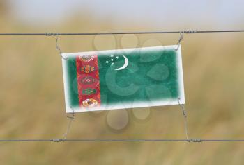 Border fence - Old plastic sign with a flag - Turkmenistan