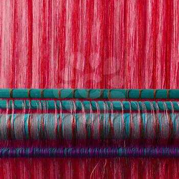 Handmade silk textile industry, silk scarf on a old machine (Vietnam), red
