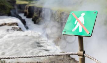 Forbidden to walk over here - Sign in Iceland - Fierce waterfall in background