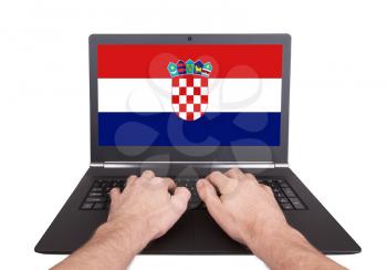 Hands working on laptop showing on the screen the flag of Croatia