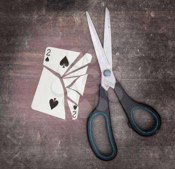 Concept of addiction, card with scissors, two of spades
