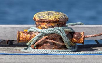 Metal bollard, many ropes on a dock