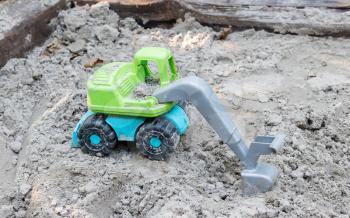 Toy trucks on sand playground, industrail symbols