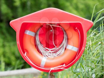 Red life buoy hanging at a lake