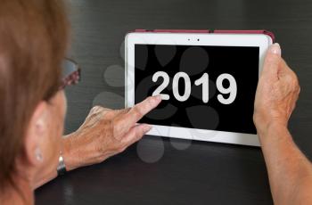 Senior lady relaxing and her tablet - New year - 2019