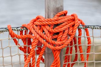Orange rope wrapped on a pole, selective focus