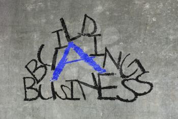 Building a business written on a chalkboard, isolated