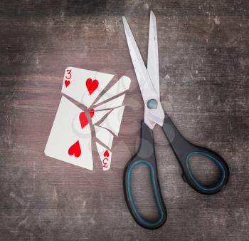 Concept of addiction, card with scissors, three of hearts