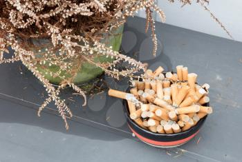 Overflowing ashtray, chain smoking, concept of unhealthy living