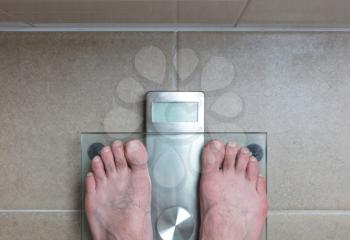 Closeup of man's feet on weight scale -