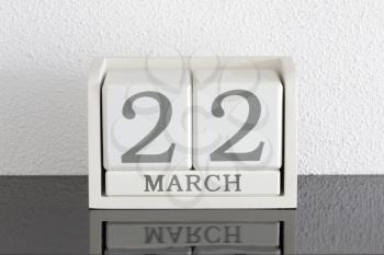 White block calendar present date 22 and month March on white wall background