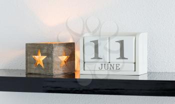 White block calendar present date 11 and month June on white wall background