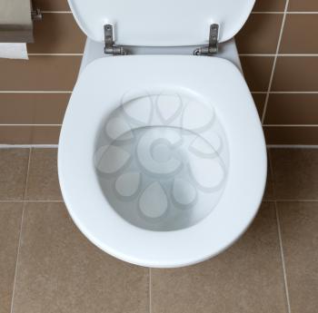 Modern white toilet bowl in the bathroom, flushing