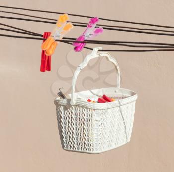 Simple white basket with clothespins, doing the loundry