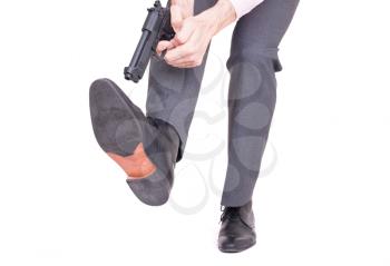 Concept - Businessman shooting himself in the foot with a handgun