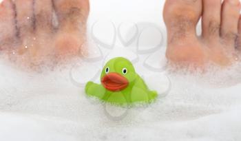 Adult man in a bathtub, rubber duck, selective focus