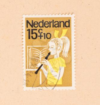 THE NETHERLANDS 1960: A stamp printed in the Netherlands shows a child playing the flute, circa 1960