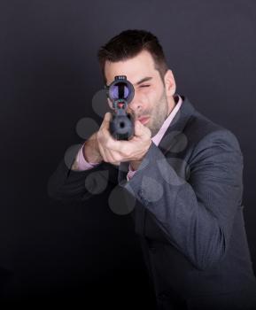Man in suit with rifle and scope, isolated on black