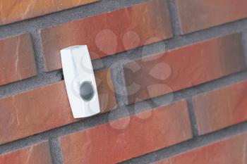 Simple doorbell on a brick wall, push to gain entrance