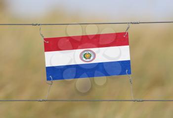 Border fence - Old plastic sign with a flag - Paraguay