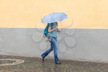 Mysterious girl walking with umbrella on rainy day