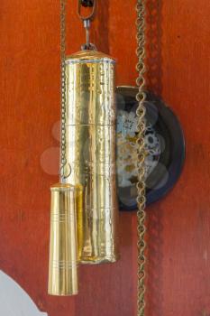 Brass weight on an old dutch clock - Selective focus