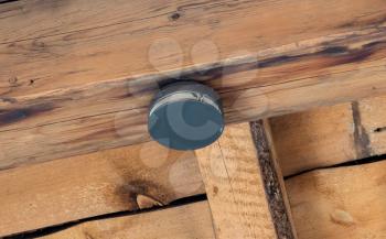 Small round battery operated device to warn residents of fire, in an old wooden house