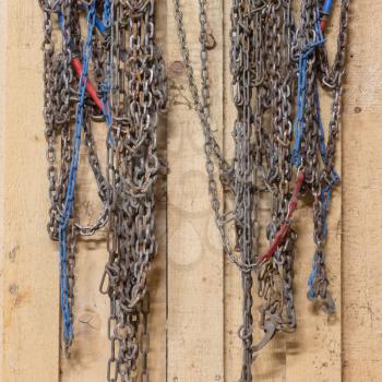 Detail shot of some old snow chains hanging in a barn
