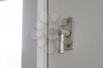 White door with security lock doorhandle, selective focus