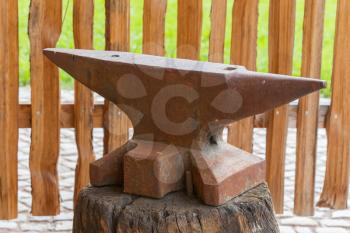 Old rusty rugged anvil on top of wood