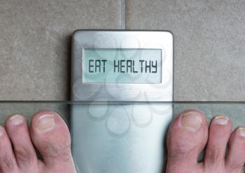 Closeup of man's feet on weight scale - Eat healthy