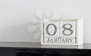 White block calendar present date 8 and month January on white wall background