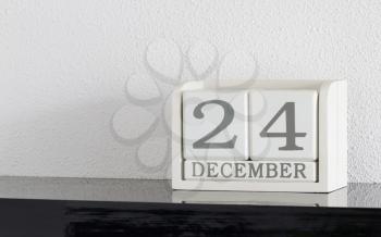 White block calendar present date 24 and month December on white wall background