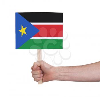 Hand holding small card, isolated on white - Flag of South Sudan