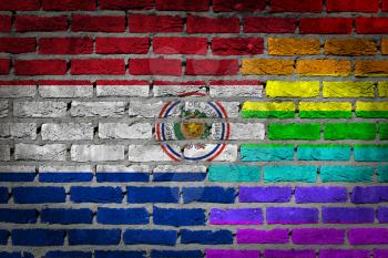 Very old dark red brick wall texture - Flag of Paraguay with rainbow flag