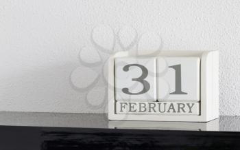 White block calendar present date 31 and month February on white wall background - Extra day