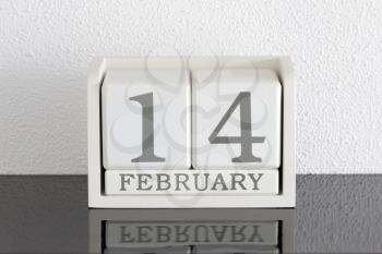 White block calendar present date 14 and month February on white wall background
