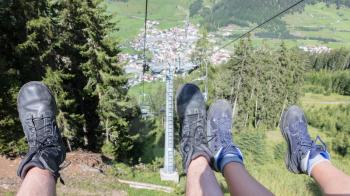 Male and female hiker riding a chairlift - Summer in Austria