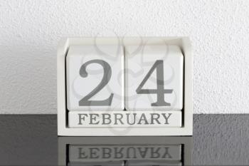 White block calendar present date 24 and month February on white wall background