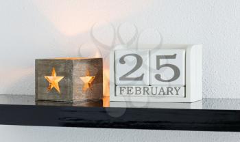 White block calendar present date 25 and month February on white wall background