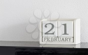 White block calendar present date 21 and month February on white wall background