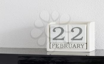 White block calendar present date 22 and month February on white wall background