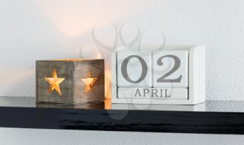 White block calendar present date 3 and month April on white wall background