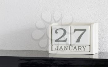 White block calendar present date 27 and month January on white wall background