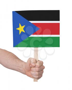 Hand holding small card, isolated on white - Flag of South Sudan